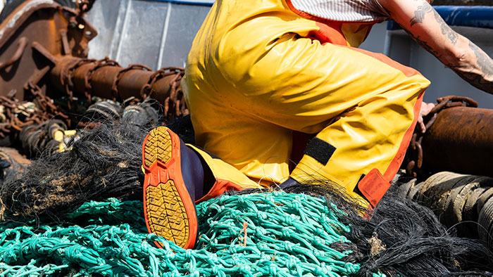 Rubber work boots on a fisherman with a net